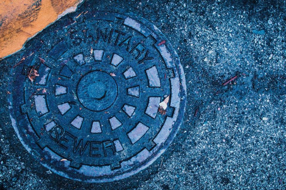 Blue manhole cover on pavement