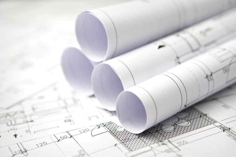 rolled up plans laying out on other plan
